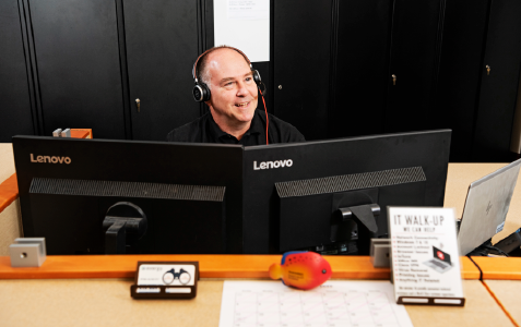 an IT professional working behind a desk, smiling