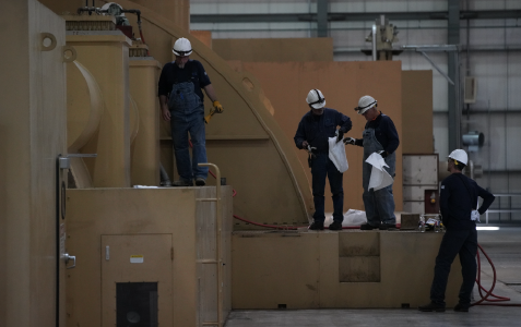 Generation professionals working on equipment in safety gear 
